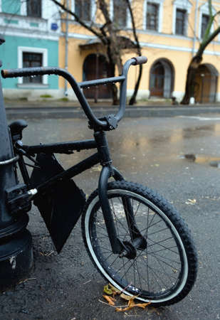 The old bicycle is parked on the street. A rainy autumn day.の写真素材