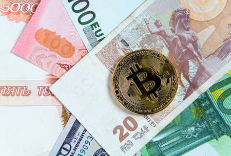 Bitcoin lies on top of banknotes. Crypto currency.の写真素材