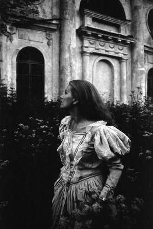 A girl in an antique dress looks away. Attention! The image contains grain and other artifacts of...