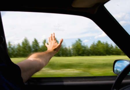 The man stuck his hand out the window of the car. In move.の写真素材