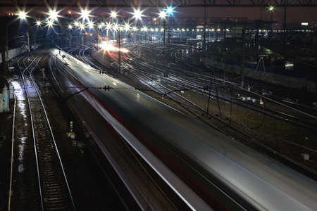 The train rushes on the rails at night. View from above.の写真素材