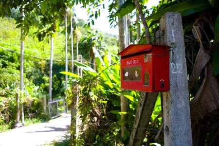 The red mailbox is fixed to the post. Thailand.