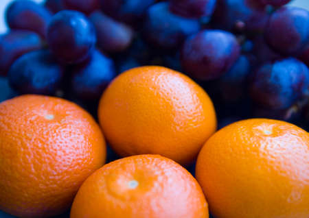 Ripe mandarins and black grapes in the background. Fruit.の写真素材