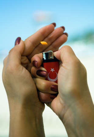 The lighter burns in beautiful female hands. Turkey.の写真素材