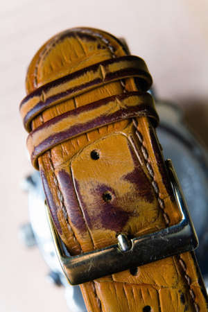 Old fastened worn strap for watches with clasp. Photographed close-up.