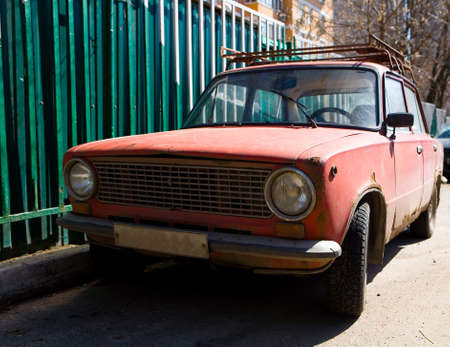 Parked old rusty red Soviet car. Without people.の写真素材