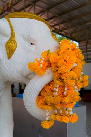 The elephant's sculpture is decorated with orange flowers. Thailand.の写真素材