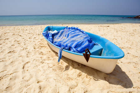 A fishing boat on the shore against the background of the sea and the cloudless sky. Thailand.の写真素材