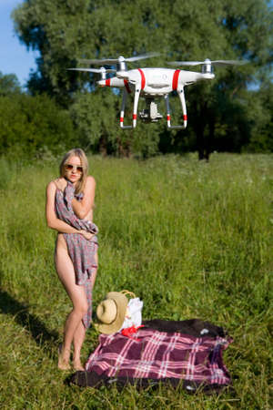 The girl covers her nakedness with her dress. The drone looks at her. Interference in private life....