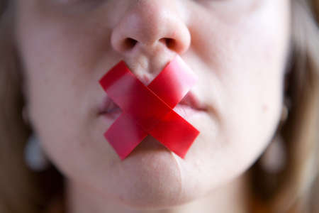 The girl's mouth is sealed with tape. Close-up.