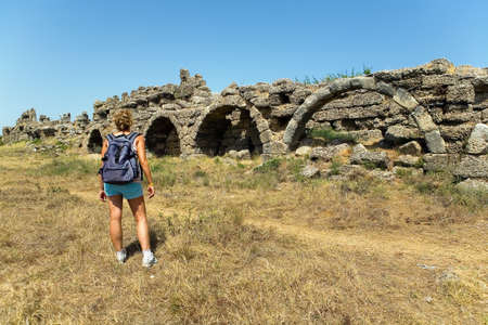 Girl traveler admires the ruins in the city of Side. Turkey.の写真素材