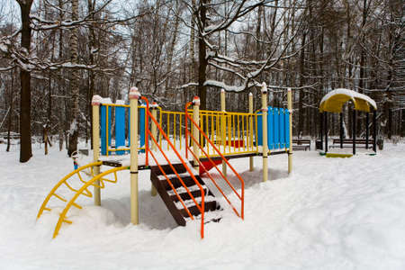 Playground in the winter park covered with snow. Russia.