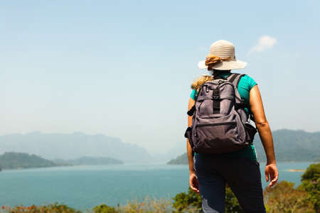 A traveler with a backpack on her back looks at the islands. Nature of Thailand.の写真素材