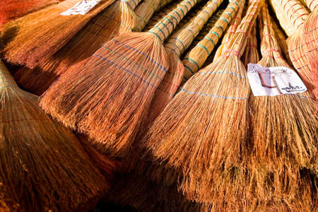 A lot of brooms for sale, on top of them lies the price tag. Georgia.