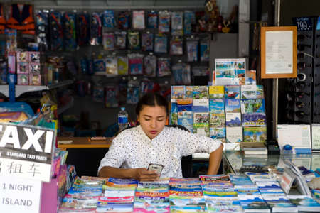 Phuket, Thailand, February 20, 2018: A beautiful young Thai woman sells sightseeing tours.