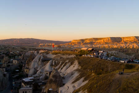 Evening top view of the small town of Goreme. People gathered on the mountain to watch the sunset in Turkish Cappadocia.の写真素材