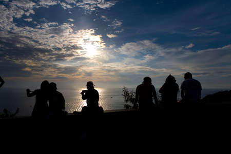 Phuket, Thailand, February 23, 2018: Silhouettes of people who watch the picturesque sunset on the sea.のeditorial素材