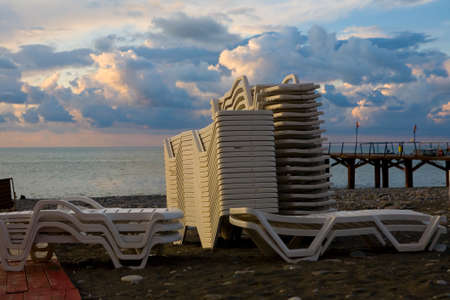 The sun loungers are stacked on the seashore. Evening in Batumi.の写真素材