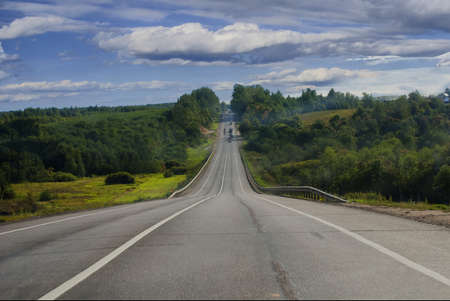 The highway with cars in the summer in a wood environmentの写真素材