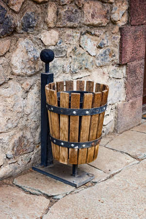garbage can in wooden registration at a stone wallの写真素材