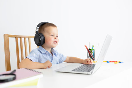 Little schoolboy talking through a laptop with a teacher or relatives, Online learning Pencils, notebooks, laptop, Education, online. High quality photoの写真素材