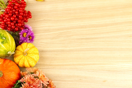 Autumn card with pumpkins, berries, flowers on a wooden background. Thanksgiving, autumn, halloween,...