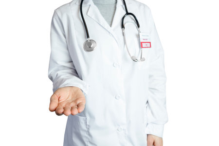 A female doctor in a white coat with a badge and a stethoscope holds out an empty hand. The doctor works in the hospital therapist, outstretched hand palm up, space for copy, isolate, white backgroundの写真素材
