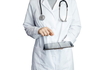 The doctor holds the tablet on a white background and presses his finger on the touch screen. A woman doctor in a white coat is seeing a patient, a touch tablet, a specialist works in a hospital, a therapistの写真素材