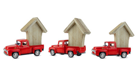Three red cars isolated on a white background, in the back of a wooden house. Small toy cars, pickup truck, wooden toy, conceptの写真素材