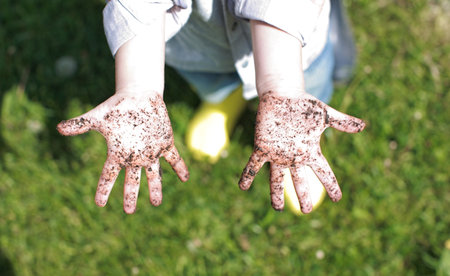 Childrens palms are stained with dirt, a child was playing in the street and got his hands dirty....