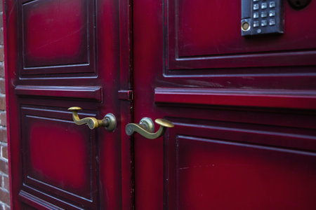 Close up of closed red front door with brass handles. Architectural door with intricate design details of traditional Portuguese buildings.の写真素材