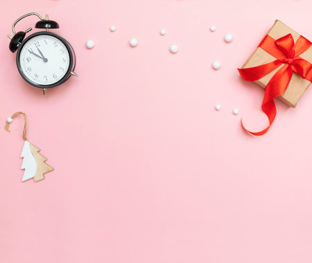 Christmas pink background with white snowflakes, New Years clock, gift, Christmas tree. Beautiful light background with space for copy, Christmas gift with red ribbon. Beautiful holiday cardの写真素材