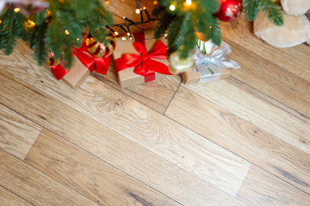 Christmas background with space for copy, Christmas tree, gifts, blurred lights. New Years photo with gifts under the tree, New Years Eve and Christmas, beautiful gifts with a red ribbon.の写真素材
