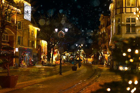 Decorated with Christmas lights, a city street with beautiful houses. Evening city on Christmas Eve with space for a copyの写真素材