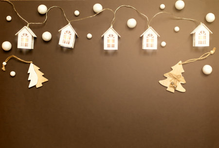 Beautiful houses with bright lights, Christmas trees, snowflakes on a brown background. Beautiful winter Christmas card with space for copy. the concept of Christmas and New Year.の写真素材