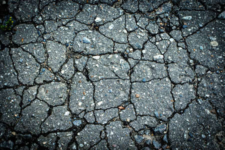 Background with old asphalt pavement in cracksの写真素材