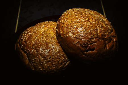 Hamburger bun with cinnamon on a dark backgroundの写真素材