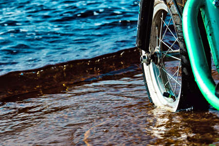 bicycle wheel on the background of the riverの写真素材