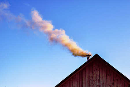 Smoke from the chimney against the skyの写真素材