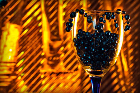 wine glass with New Year's beads on a colorful backgroundの写真素材