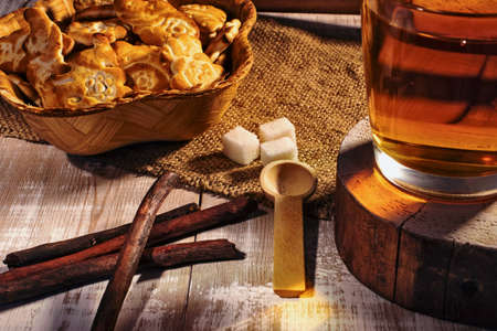 still life with tea mug, sugar and cookies on a wooden tableの写真素材
