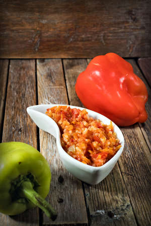 bell pepper with rice and tomato sauce on a wooden tableの写真素材