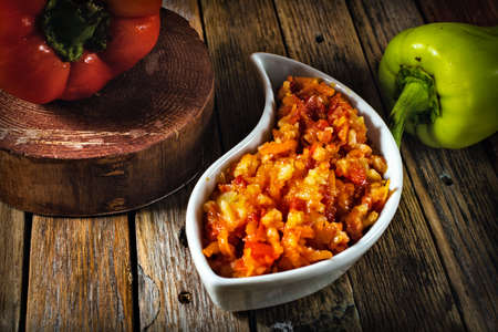 bell pepper with rice and tomato sauce on a wooden tableの写真素材