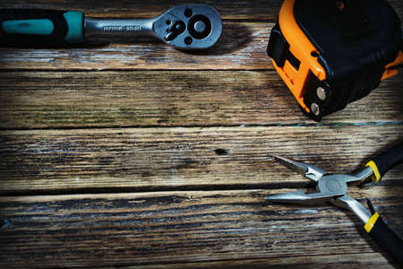 tape measure and pliers on a wooden backgroundの写真素材