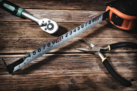 tape measure and pliers on a wooden backgroundの写真素材