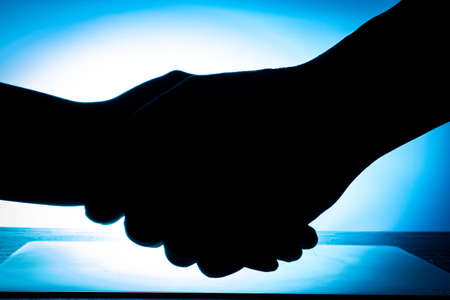 background with handshake over the tableの写真素材