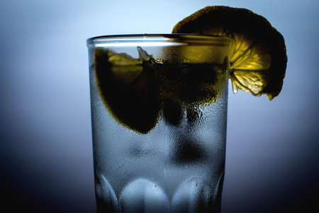 cocktail with ice and lemon in a misted glassの写真素材