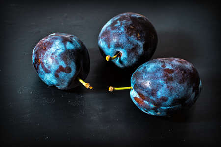three plums on black backgroundの写真素材