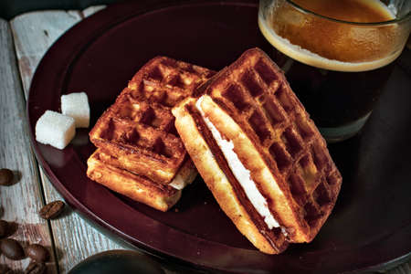 cup of coffee and viennese waffles on a wooden tableの写真素材