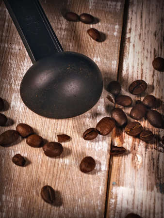 Measuring spoon for coffee maker and coffee beans on wooden backgroundの写真素材